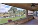 Relaxing screened patio with brick trim offering serene lake views and a ceiling fan at 111 Brown Crane Ct, Daytona Beach, FL 32119