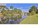 The home has a stunning water view with mature trees against a blue sky at 111 Brown Crane Ct, Daytona Beach, FL 32119