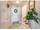 Bright hallway with white walls, a decorative wreath, and a glimpse into the well-lit condo at 1224 S Peninsula Dr # 210, Daytona Beach, FL 32118