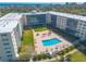 Aerial view of a condominium featuring a pool with chairs, lawn and view to the ocean at 1224 S Peninsula Dr # 210, Daytona Beach, FL 32118