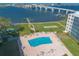 An aerial view shows the pool, shuffleboard and waterfront views with a bridge in the background at 1224 S Peninsula Dr # 210, Daytona Beach, FL 32118