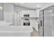 Well-lit kitchen featuring stainless steel appliances, white cabinets, and a quartz breakfast bar at 1329 N Old Mill Dr, Deltona, FL 32725