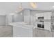 Bright kitchen boasts stainless appliances, white cabinetry, and modern pendant lighting at 1329 N Old Mill Dr, Deltona, FL 32725
