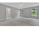 Spacious main bedroom featuring carpeted floors, tray ceilings, and ensuite bathroom access at 1329 N Old Mill Dr, Deltona, FL 32725