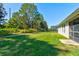 Spacious backyard with lush green grass, mature trees, and manicured garden beds offers privacy at 1423 Chelsea Manor Cir, Deland, FL 32724