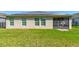 The home's backyard features a well-maintained lawn, solar panels, and a screened-in porch at 1423 Chelsea Manor Cir, Deland, FL 32724