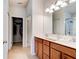 Double vanity sinks in the main bathroom, with wooden cabinets, tile floors, and an open door to closet at 1423 Chelsea Manor Cir, Deland, FL 32724