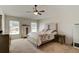 Bright bedroom featuring neutral carpet, a ceiling fan, and a comfortable queen-sized bed at 1423 Chelsea Manor Cir, Deland, FL 32724