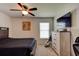 Spacious bedroom featuring a large bed, ceiling fan, and a dresser with mounted TV at 1423 Chelsea Manor Cir, Deland, FL 32724