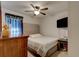 Comfortable bedroom with ceiling fan, TV, and a stylish upholstered headboard at 1423 Chelsea Manor Cir, Deland, FL 32724