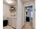 Functional laundry area with washer, dryer, and convenient shelving for storage at 1423 Chelsea Manor Cir, Deland, FL 32724