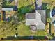 Aerial view of a landscaped property featuring a metal roof, fenced-in yard, and lush greenery at 1493 Derbyshire Rd, Daytona Beach, FL 32117
