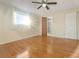 Sun-filled bedroom boasts hardwood floors, a ceiling fan, and a window for natural light at 1493 Derbyshire Rd, Daytona Beach, FL 32117