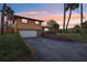Exterior of home at sunset, featuring attached garage and front yard at 1493 Derbyshire Rd, Daytona Beach, FL 32117