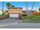 Two-story home featuring a front yard, two-car garage, and a durable metal roof at 1493 Derbyshire Rd, Daytona Beach, FL 32117