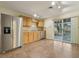Kitchen with stainless steel appliances, tile backsplash, and sliding door access to backyard at 1493 Derbyshire Rd, Daytona Beach, FL 32117