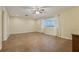 Expansive living room with tile flooring, ceiling fan, and two large windows at 1493 Derbyshire Rd, Daytona Beach, FL 32117