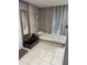 A compact bedroom with a striped single bed, tiled floor, mirror, and a small bedside table at 1572 Darlington Ave, Deltona, FL 32725