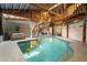 Bright indoor pool surrounded by wood beams, steps, and comfortable seating for relaxation and enjoyment at 1572 Darlington Ave, Deltona, FL 32725