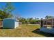 Lush backyard featuring a pool, shed, screened-in patio, and privacy fence at 1609 Raleigh Ave, Daytona Beach, FL 32117
