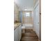 Bathroom featuring a tub with tile surround, modern vanity, and wood-look flooring at 1609 Raleigh Ave, Daytona Beach, FL 32117