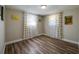 Well-lit bedroom with modern wood floors and two windows that provide plenty of natural light at 1609 Raleigh Ave, Daytona Beach, FL 32117