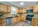 Well-lit kitchen with stainless steel appliances, granite counters, and light wood cabinets at 1609 Raleigh Ave, Daytona Beach, FL 32117