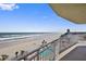 Balcony view of the beach, ocean, palm trees, and community pool below at 1900 N Atlantic Ave # 504, Daytona Beach, FL 32118