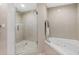 Modern bathroom with glass shower, soaking tub, and tiled walls at 1900 N Atlantic Ave # 504, Daytona Beach, FL 32118