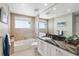 Well-lit bathroom with stylish vanity, granite countertop, and tiled shower-tub combo at 1900 N Atlantic Ave # 504, Daytona Beach, FL 32118