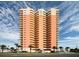 Stunning exterior view of a multi-story condominium building with curved balconies and lush landscaping at 1900 N Atlantic Ave # 504, Daytona Beach, FL 32118