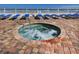 Community hot tub with beach access and lounge chairs, with a glimpse of the ocean in the background at 1900 N Atlantic Ave # 504, Daytona Beach, FL 32118