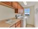 Functional laundry room with wooden cabinets, modern washing machine and dryer, and a view to the outside at 1900 N Atlantic Ave # 504, Daytona Beach, FL 32118