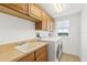Bright laundry room featuring modern washer and dryer with overhead cabinetry at 1900 N Atlantic Ave # 504, Daytona Beach, FL 32118