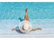 A Personal relaxing in the pool with a straw hat, clear water, and sun-drenched atmosphere at 1900 N Atlantic Ave # 504, Daytona Beach, FL 32118