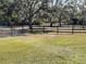 Fenced backyard and grassy field provide a secure and spacious outdoor area at 1990 Spruce Creek N Cir, Port Orange, FL 32128