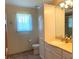 Bathroom featuring earth-tone tile, granite vanity, modern hardware, and a bright window at 1990 Spruce Creek N Cir, Port Orange, FL 32128