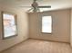 Empty carpeted bedroom with light beige walls and natural light from two bright windows at 1990 Spruce Creek N Cir, Port Orange, FL 32128