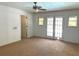 Bedroom featuring a ceiling fan, French doors, and neutral carpeting at 1990 Spruce Creek N Cir, Port Orange, FL 32128