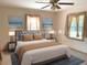 Staged bedroom featuring two beach-themed pictures and neutral furniture and decorations at 1990 Spruce Creek N Cir, Port Orange, FL 32128