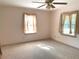 Bedroom featuring light-colored walls and carpet, neutral decor, and two bright windows at 1990 Spruce Creek N Cir, Port Orange, FL 32128