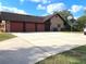 Spacious three-car garage featuring a basketball hoop and expansive driveway, great for entertainment at 1990 Spruce Creek N Cir, Port Orange, FL 32128