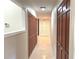 Hallway with tan tile flooring and dark wood storage closets with brushed nickel hardware at 1990 Spruce Creek N Cir, Port Orange, FL 32128