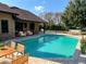 Swimming pool with deck furniture, landscaping and brick exterior at 1990 Spruce Creek N Cir, Port Orange, FL 32128