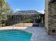 The screened porch includes a brick patio and a view of the beautiful, fenced-in backyard and pool at 1990 Spruce Creek N Cir, Port Orange, FL 32128