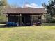 Outdoor shed with tractor and lawnmowers provides ample storage for equipment and tools at 1990 Spruce Creek N Cir, Port Orange, FL 32128
