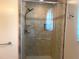 Tiled shower with glass door, shower head, built-in shelves and handrail at 1990 Spruce Creek N Cir, Port Orange, FL 32128