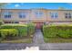 Inviting two-story townhome with a private entrance framed by manicured hedges and lush landscaping at 200 Saint Andrews Blvd # 2804, Winter Park, FL 32792