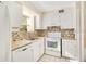 A bright kitchen is equipped with white cabinetry and a window over the sink at 200 Saint Andrews Blvd # 2804, Winter Park, FL 32792