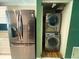 Convenient laundry area with stainless steel refrigerator and stacked washer and dryer at 2044 7Th Ave, Deland, FL 32724